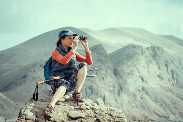 Турист с рюкзаком отдыхает на вершине горы — стоковое фото