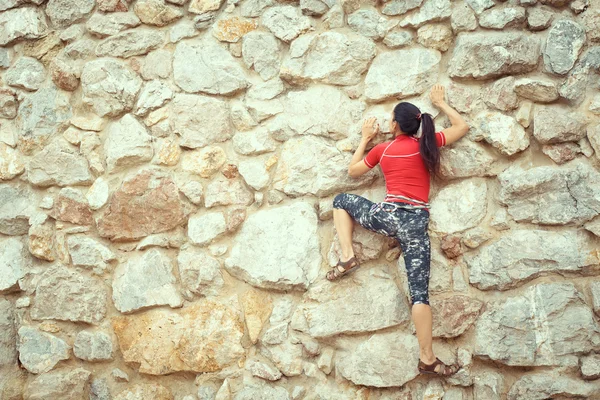 Mujer feliz sube una roca mientras que trekking al aire libre —  Fotos de Stock