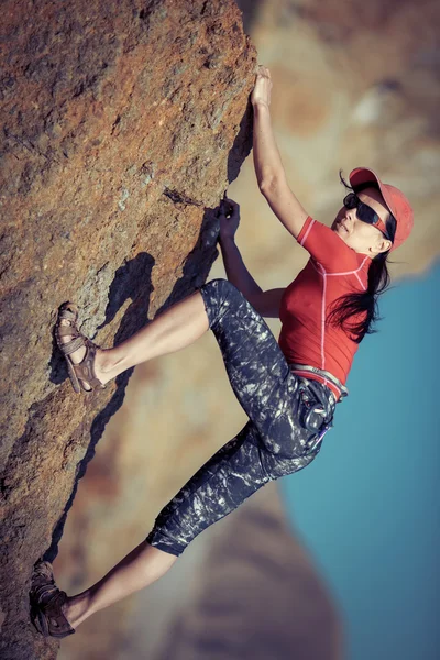 Mujer feliz sube una roca mientras que trekking al aire libre — Foto de Stock