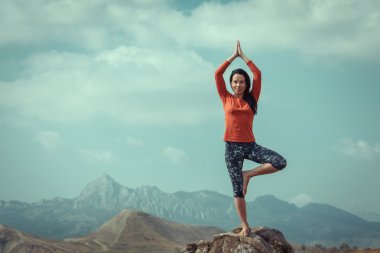 Kız yoga okyanus, ağaç poz bir arka plan üzerinde çalışmaktadır