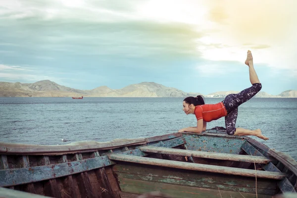 Kaukasisk kvinna utövar yoga på stranden — Stockfoto