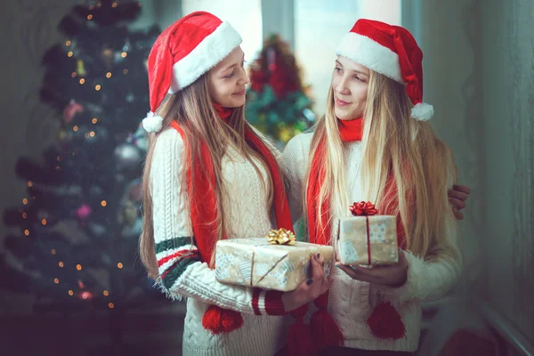 Две девушки перед елкой с подарками — стоковое фото