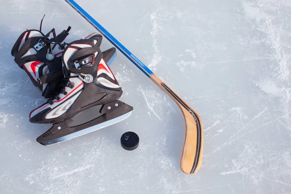 Hockeyschläger und Puck auf der Eisbahn. — Stockfoto