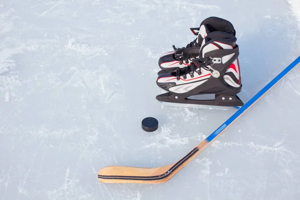 Hockeyschläger und Puck auf der Eisbahn. — Stockfoto