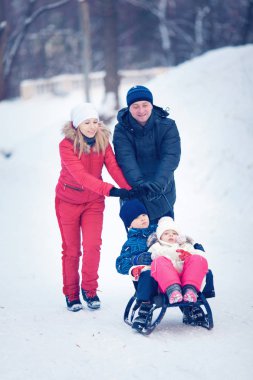 Genç Aile Kızakla Karda Koşuyor