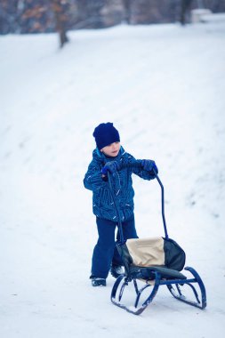 Genç yakışıklı o sledging gibi kar ile püskürtülür