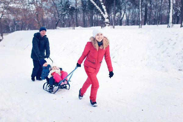 Junge Familie läuft mit Schlitten durch Schnee — Stockfoto