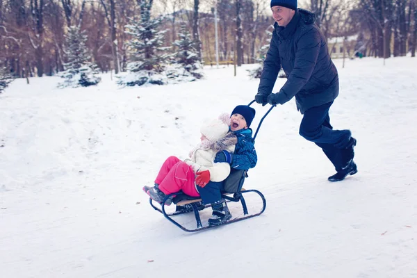 Junge Familie läuft mit Schlitten durch Schnee — Stockfoto