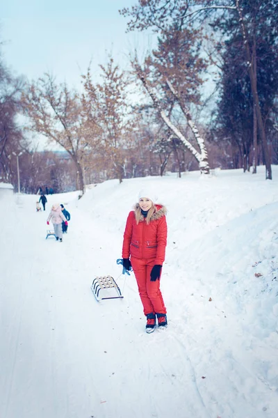 Giovane famiglia correre attraverso la neve con slitta — Foto Stock