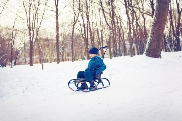 可爱的小男孩，雪橇在雪中 — 图库照片