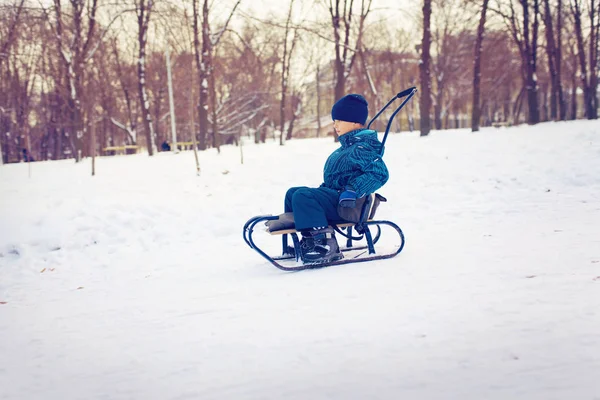 可爱的小男孩，雪橇在雪中 — 图库照片