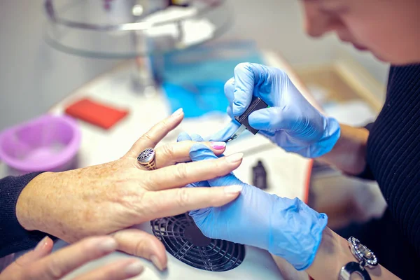 El proceso de manicura en el salón de belleza el primer plano de las manos femeninas — Foto de Stock