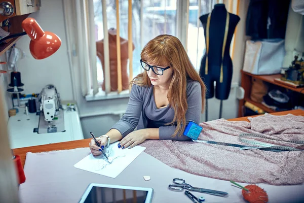 Mode-ontwerper kijken naar schetsen in studio — Stockfoto