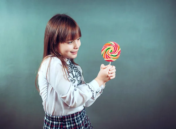 Веселая красивая девушка, держащая конфеты подмигивает смеется показывает язык — стоковое фото