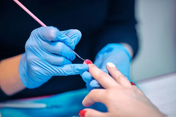 Mestre aplicando polonês em unhas na mulher — Fotografia de Stock