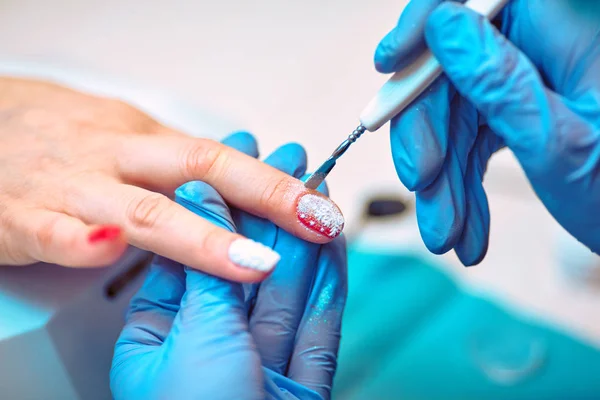Master aanbrengen polijsten op nagels op vrouw — Stockfoto