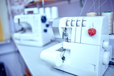 Terzi iş parçacığı eski dikiş makinesinde ekler.