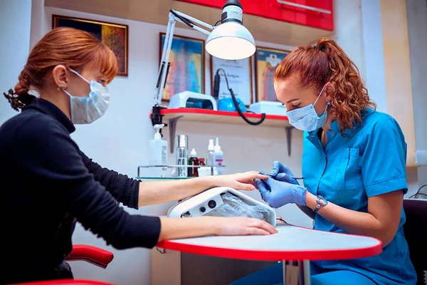 Processo de manicure em salão de beleza perto de mãos femininas — Fotografia de Stock