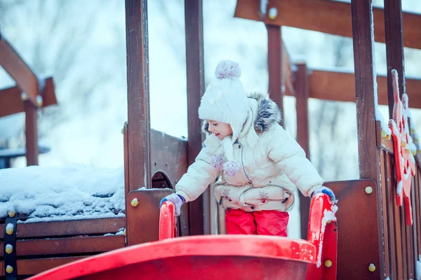 Happy child girl on swing in sunset winter. — Stock Photo, Image