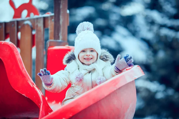 Happy child girl on swing in sunset winter. — Stock Photo, Image