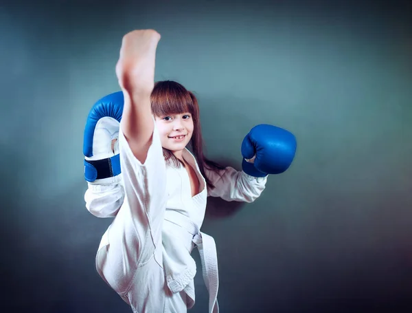 Karate meisje het vervult kicks op achtergrond — Stockfoto