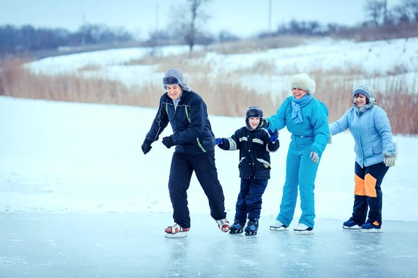 Família com criança na pista de patinação no gelo — Fotografia de Stock