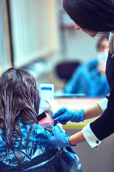 Brunetka kobieta umiera jej włosy w salonie kosmetycznym — Zdjęcie stockowe