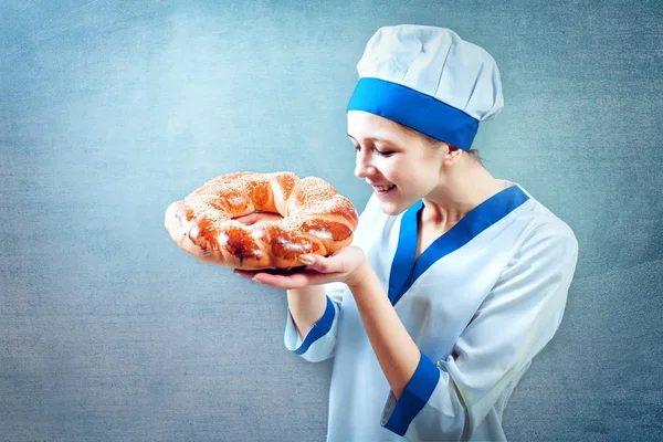 Baker tittar på nybakat bröd i bageriet — Stockfoto