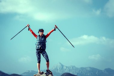 Sırt çantalı bir yürüyüşçü dağın tepesinde dinleniyor. 