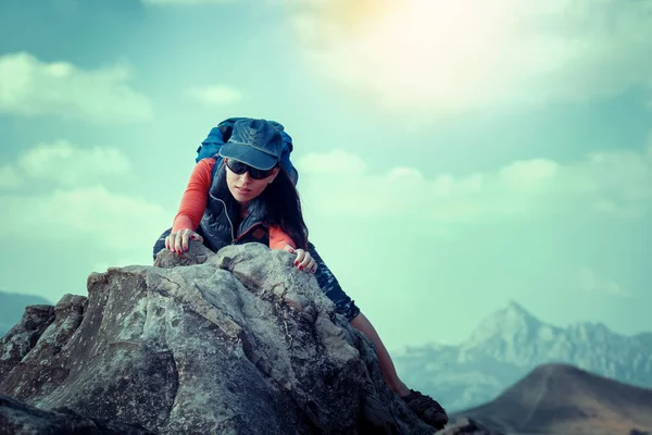 Mulher feliz sobe uma rocha enquanto trekking ao ar livre. despreocupado de volta — Fotografia de Stock