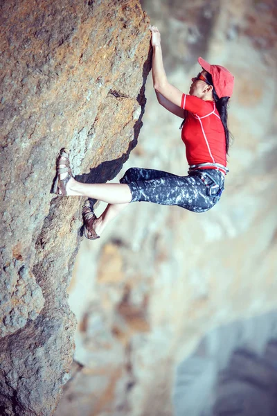 Happy woman climbs a rock while trekking outdoors — Stock Photo, Image