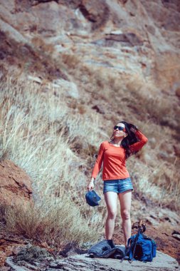 Büyük taşlar üzerinde duran sırt çantası ile genç yolcusu 