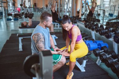 Spor salonunda fitness makinede egzersiz yaparken çift. 