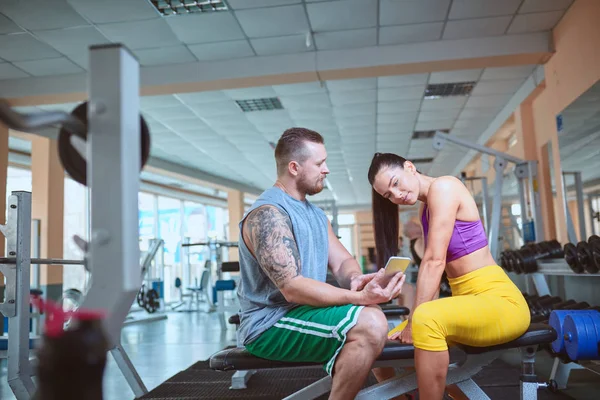 Pareja haciendo ejercicio en la máquina de fitness en el gimnasio . — Foto de Stock