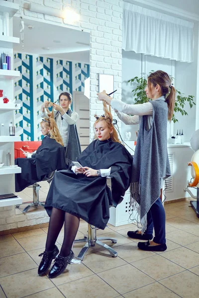 Hair styling in a beauty salon .