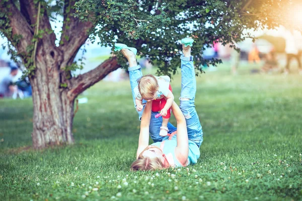 Šťastná rodina tří ležící v trávě . — Stock fotografie