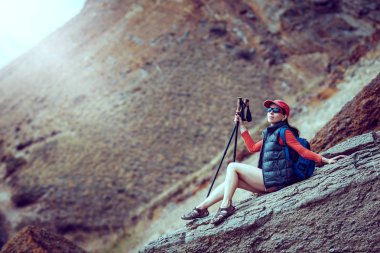 Büyük taşlar üzerinde duran sırt çantası ile genç yolcusu 