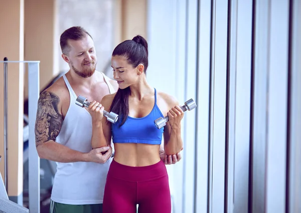 Mujer haciendo ejercicio de empuje bajo la supervisión de un entrenador — Foto de Stock