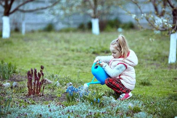 女の子の庭師は庭の花に水をまく . — ストック写真