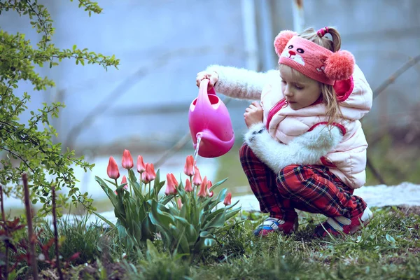 Flicka trädgårdsmästare vattna blommor i trädgården . — Stockfoto