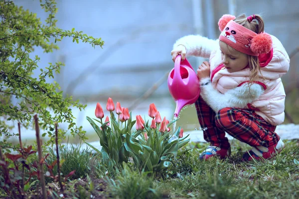 Flicka trädgårdsmästare vattna blommor i trädgården . — Stockfoto