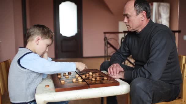 Bonito homem jogando damas com seu neto — Vídeo de Stock
