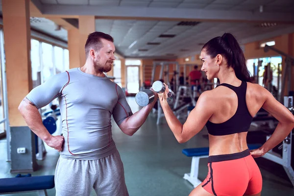 Pareja haciendo ejercicio en la máquina de fitness en el gimnasio . — Foto de Stock