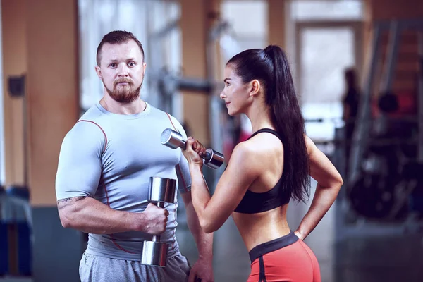 Pareja haciendo ejercicio en la máquina de fitness en el gimnasio . — Foto de Stock