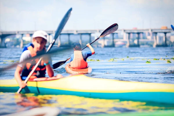 Junge Leute paddeln auf einem Fluss in schöner Natur. — Stockfoto