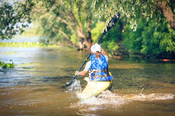 Junge Leute paddeln auf einem Fluss in schöner Natur. — Stockfoto