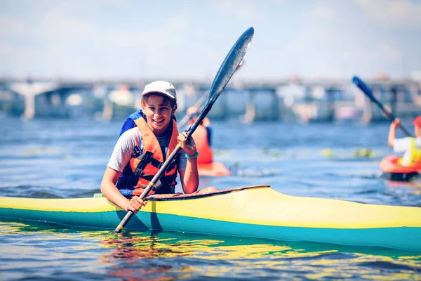 Junge Leute paddeln auf einem Fluss in schöner Natur. — Stockfoto