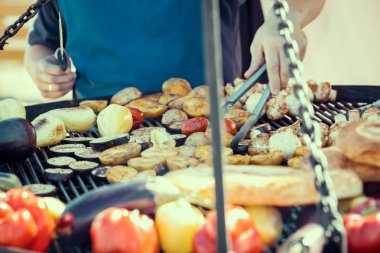 Adam aile akşam yemeği için ızgara üzerinde pişirme