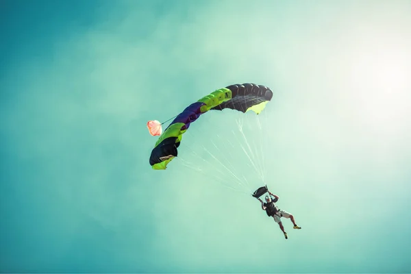 Парашутист на барвисті парашутом в Сонячний чисте небо. — стокове фото