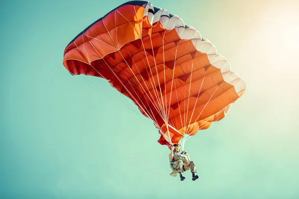 Skydiver στο πολύχρωμο αλεξίπτωτο σε καθαρό ηλιόλουστο ουρανό. — Φωτογραφία Αρχείου